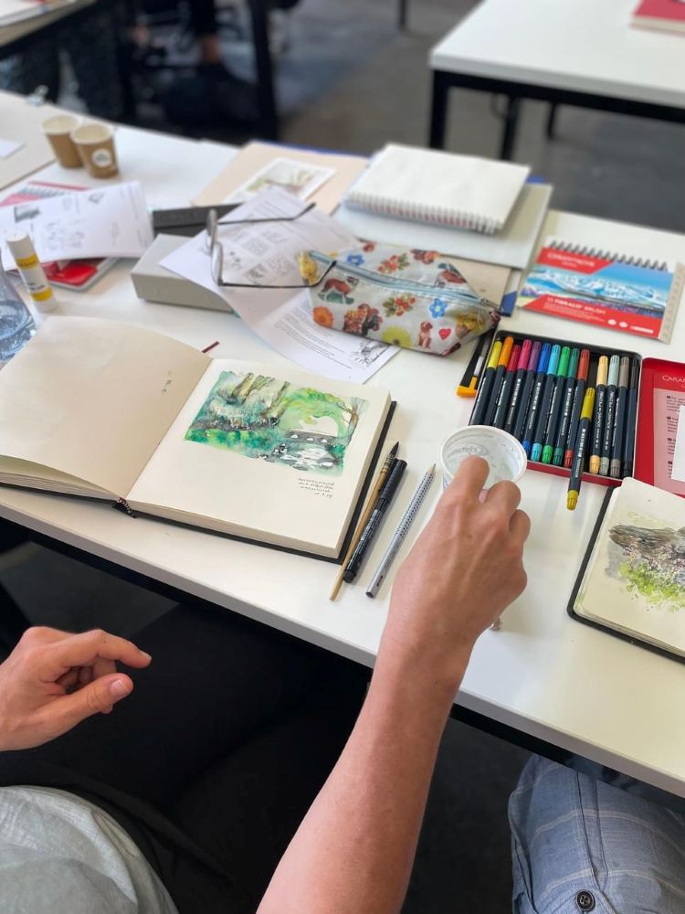 Lehrerinnen und Lehrer gestalten mit Farben und Pinseln kreative Bilder